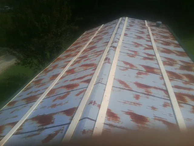 Rusted metal roof panels with new wood purlins before replacement — Storm Damage Roof Repair in Ferris by Roofing Brothers
